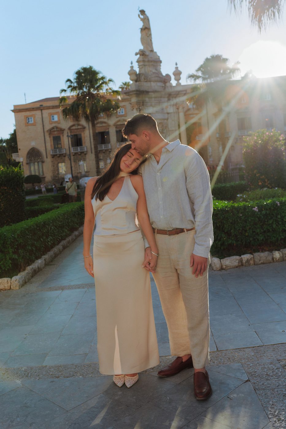The couple in golden evening light by a fountain